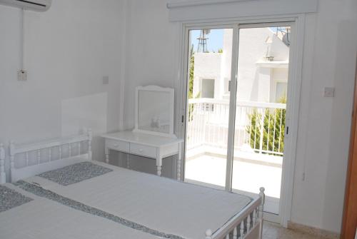 普罗塔拉斯佛斯霍斯海滩公寓 的白色的客房设有两张床和窗户。