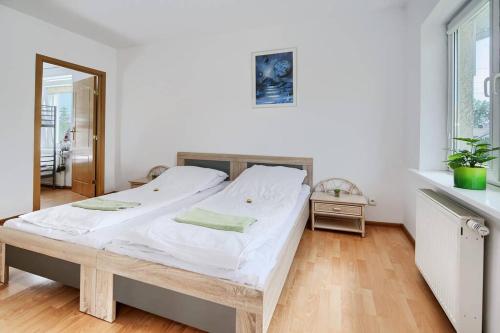 格但斯克Happiness House Balcony & Nice Garden的一间卧室配有一张带白色床单的大床