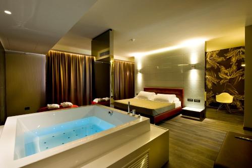 格鲁梅洛德尔蒙泰中提琴M酒店的带浴缸的浴室和1间带1张床的卧室