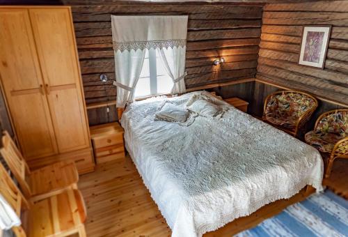 HiieväljaSihi Country House的一间卧室配有一张床、两把椅子和一个窗户