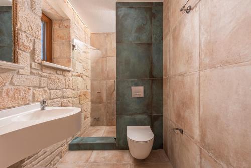卡兰兹拉Mint Retreat Suites的带浴缸、卫生间和盥洗盆的浴室