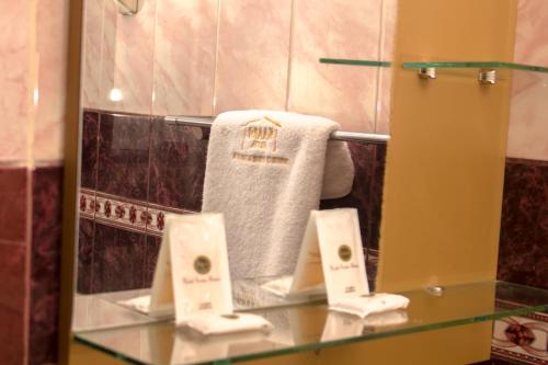普诺Kaaro Hotel Puno的毛巾浴室内的玻璃架