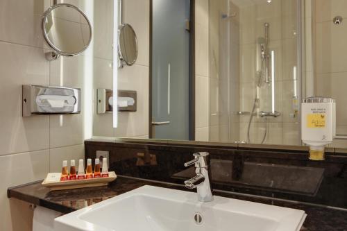 汉诺威汉诺威城际酒店 的一间带水槽、淋浴和镜子的浴室
