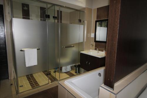 约翰内斯堡Alcazaba Lodges的一间带玻璃淋浴和水槽的浴室
