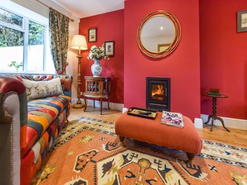 MinchinhamptonHyde Tyning Cottage的带沙发和镜子的客厅