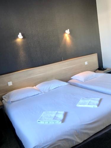 GorronHôtel le Bretagne et Restaurant Le Papillon的两张位于酒店客房的床,配有两条毛巾