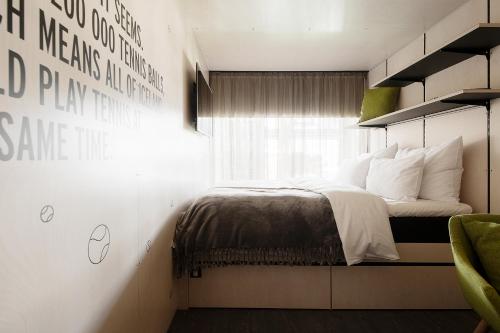 塔林Hektor Container Hotel的卧室配有带白色枕头的床和窗户。