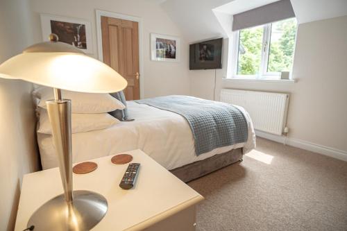 GilwernMill Lodge-Brecon Beacons的一间卧室配有一张床和一张桌子上的台灯