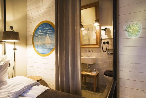 斯德哥尔摩乌尔桑达斯劳特酒店的浴室设有床、水槽和镜子