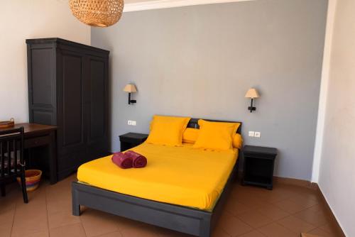 迭戈苏瓦雷斯维多利亚酒店的一间卧室配有一张带黄色床单和黄色枕头的床。