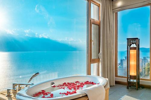 大理大理哒惹海景度假别院的带浴缸的浴室和大窗户