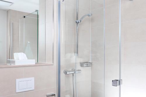 纽伦堡阿尔法酒店的浴室里设有玻璃门淋浴
