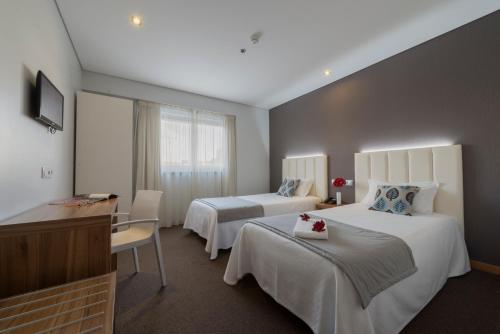 法蒂玛阿金海拉酒店的酒店客房配有两张床和一张书桌