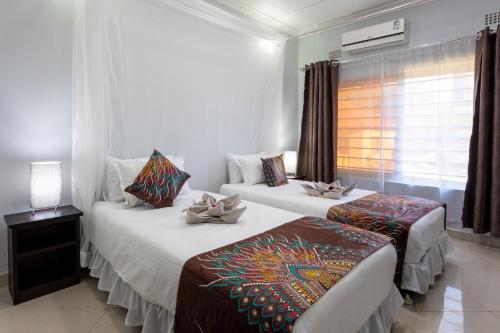 利文斯顿Nzubo Experience的配有窗户的酒店客房内的两张床