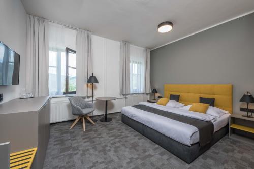 什平德莱鲁夫姆林普拉哈酒店的一间卧室配有一张床、一张桌子和一把椅子