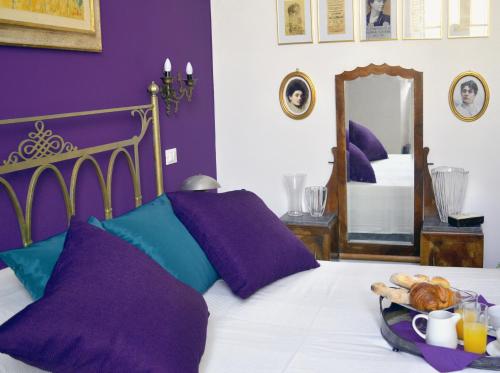利沃诺900的一间卧室配有一张带紫色墙壁和镜子的床