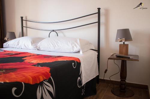 维泰博La Gazza的一间卧室配有一张床和一张带台灯的桌子