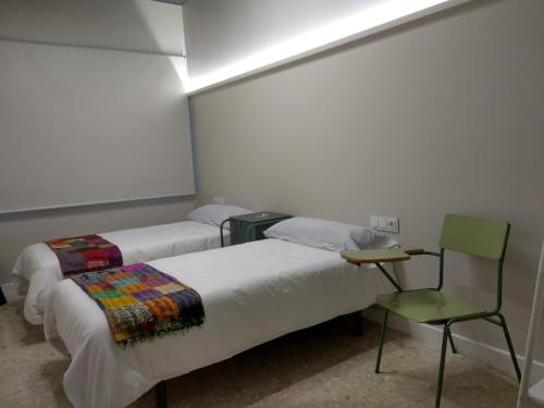 庞特维德拉Acolá Rooms的一间设有两张床和椅子的房间