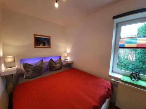 奥斯特巴德·哥伦Ferienwohnungen Göhren的一间卧室设有红色的床和窗户。