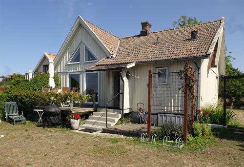 比克瑟尔克鲁克1B, Stuga m havsutsikt & 50m till strand的白色的房子,设有门廊和围栏