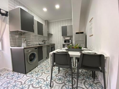 埃尔瓦斯Largo d Vizinha Bia的厨房配有桌椅和洗衣机。