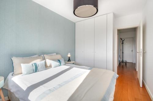 里斯本Welcome Here - Tamisa - Parque das Nações的卧室配有白色床和蓝色墙壁