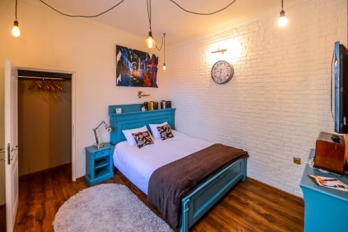锡吉什瓦拉ATRIUM 24 Suite的一间卧室设有蓝色的床和砖墙