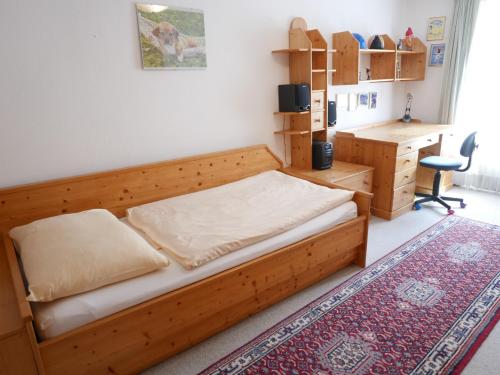哈莱恩Stadtwohnung Franz bis 6 Personen Hallein bei Salzburg的一间卧室配有一张木床和一张书桌
