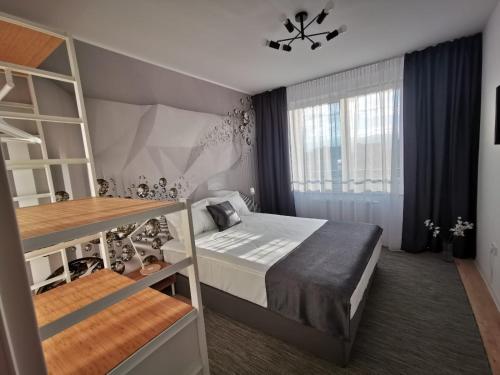 布拉索夫Cliché Luxury Apartment的一间小卧室,配有床和窗户