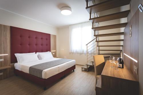 瓦达Hotel Residence Vallecorsa的一间卧室配有一张大床和红色床头板