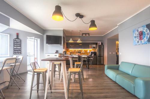 蓬塔德尔加达Atlantic Home Azores的一间带蓝色沙发的客厅和一间厨房