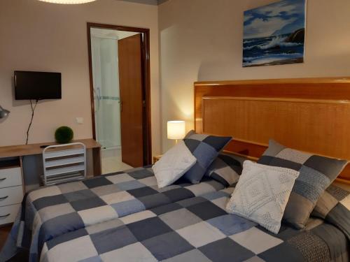 维拉多比斯坡Casa Mestre的一间卧室配有一张床、一张书桌和一台电视