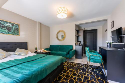 米兹多洛杰Złota Regalinda & Spa的酒店客房,设有一张床铺和一张绿色沙发