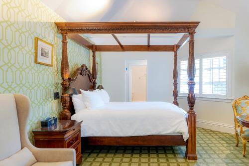 卡利斯托加柏格森住宿加早餐旅馆的一间卧室配有一张天蓬床和一把椅子