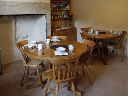 Haydon BridgeThe Reading Rooms的用餐室配有木桌、椅子和壁炉