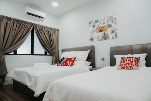 关丹Exclusive Double Storey Homestay Kuantan的一间卧室配有两张带白色床单和红色枕头的床。