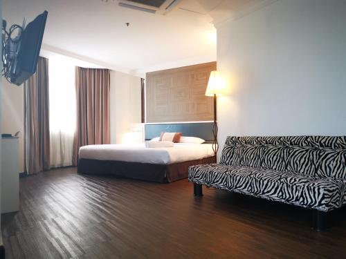 怡保怡保麗閣酒店的酒店客房,配有床和沙发