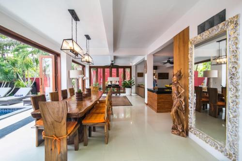 八丹拜CASA MIMBA - Seaview Private Pool Villa Padangbai的用餐室配有木桌、椅子和镜子