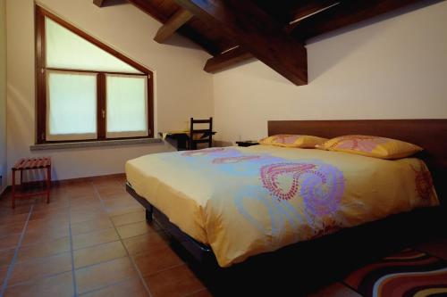 GatticoAgriturismo Altana Del Motto Rosso的一间带床的卧室,位于带窗户的房间内