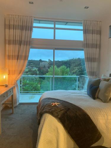 阿卡罗阿Love Akaroa Retreat的一间卧室设有一张床和一个大窗户