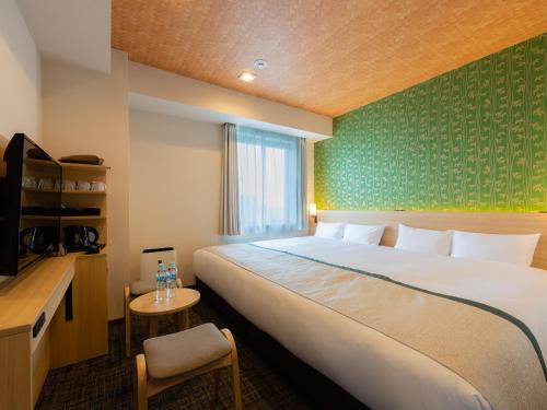 东京Tosei Hotel Cocone Asakusa Kuramae的酒店客房带一张大床和一把椅子