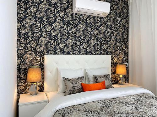马德里Palacio Apartments Madrid的一间卧室配有一张黑色和白色壁纸的床