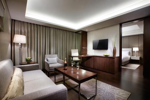 大田LOTTE City Hotel Daejeon的带沙发、床和电视的客厅