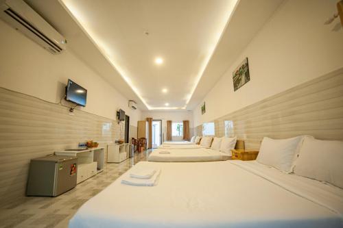 朱笃FaMi Nguyễn Homestay Châu Đốc的一间设有三张床和一台电视的房间