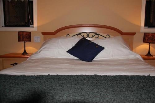 基洛纳鹌鹑岭度假天堂住宿加早餐旅馆的一张带蓝色枕头的床和两盏灯