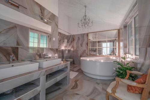 布德瓦马里内罗公寓的大型浴室设有两个盥洗盆和浴缸。