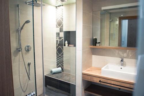 迈尔霍芬423 - Penthouse apartment centrum Mayrhofen near ski area的带淋浴、盥洗盆和盥洗盆的浴室