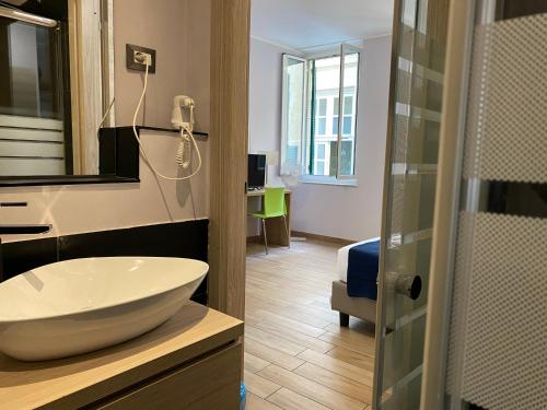 热那亚甘智亚娜酒店的一间带白色水槽的浴室和一间房间