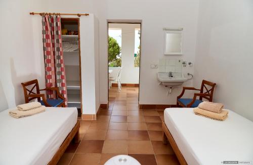 米乔尔海滩Can Nigg的客房设有两张床和一间带水槽的浴室