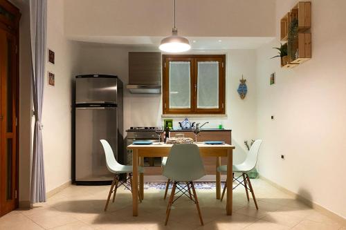 焦维纳佐La Rotonda - Casa vacanze的厨房配有桌椅和冰箱。